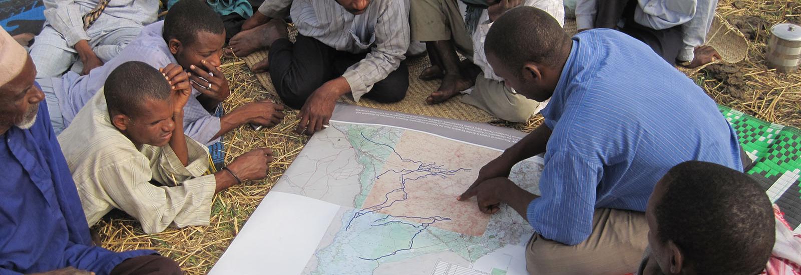 Researcher goes over maps with locals abroad