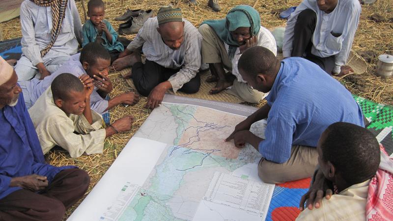 Researcher goes over maps with locals abroad